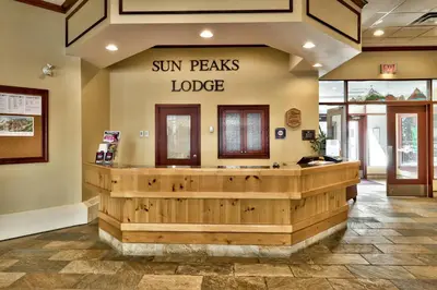 a sun peaks lodge lobby with a sign on the wall at Sun Peaks Lodge in Sun Peaks