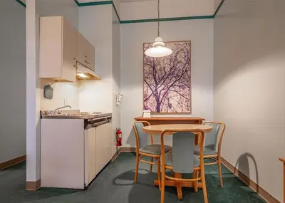 a kitchen with a table and chairs in a room at The Cedars Inn Hotel & Convention Centre in Gibsons