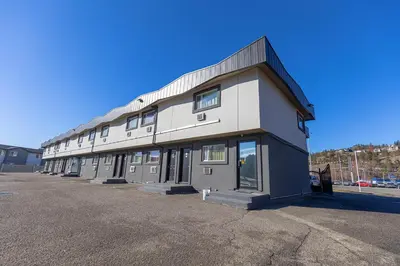 a building with a lot of windows in a parking lot at Canadas Best Value Inn Kelowna in Kelowna