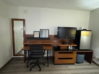 a desk with a computer and a monitor and a chair at Canadas Best Value Inn Kelowna in Kelowna