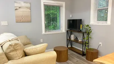 a living room with a couch and a tv and two windows at Bonniebrook Lodge in Gibsons
