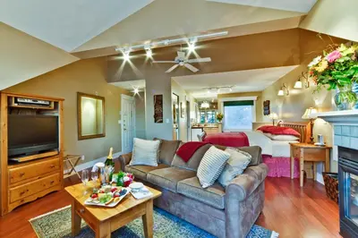 a living room with a couch and a bedroom at Bonniebrook Lodge in Gibsons