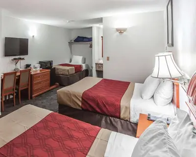 a hotel room with two beds and a television at Econo Lodge Inn & Suites Drumheller in Drumheller