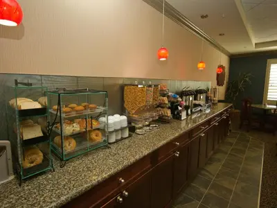 a kitchen with a counter with a bunch of pastries at Redwood Inn & Suites in Clairmont