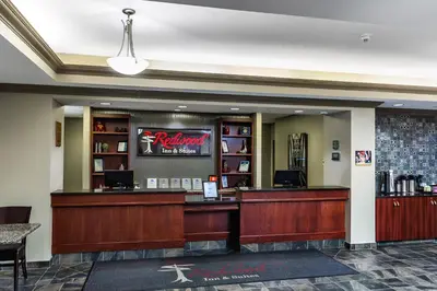 a restaurant with a bar in the lobby of a hotel at Redwood Inn & Suites in Clairmont