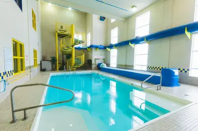 a swimming pool with blue water in a building at Redwood Inn & Suites in Clairmont