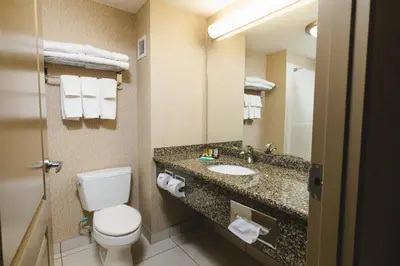 a hotel bathroom with a toilet and a sink at Redwood Inn & Suites in Clairmont