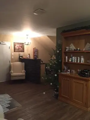 a living room with a christmas tree and a chair at Spruce Hill Resort & Spa in 108 Mile Ranch
