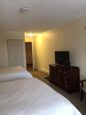 a bedroom with two beds and a television on a dresser at Spruce Hill Resort & Spa in 108 Mile Ranch