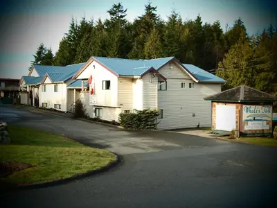 a row of white houses with blue roofs on a street at Whale's Tail Guest Suites in Ucluelet