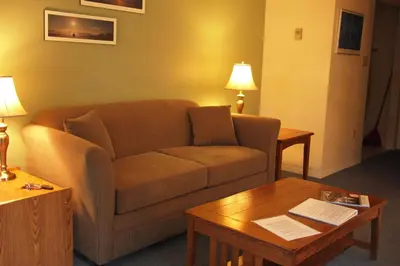 a living room with a couch and a coffee table at Whale's Tail Guest Suites in Ucluelet