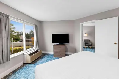 a hotel room with a bed and a flat screen tv at Hotel Feng, BW Signature Collection in Parksville