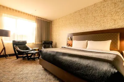 a hotel room with a bed and a chair at Hotel Zed Tofino in Tofino