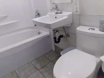 a bathroom with a white toilet and a sink at Dolphin Motel in Tofino