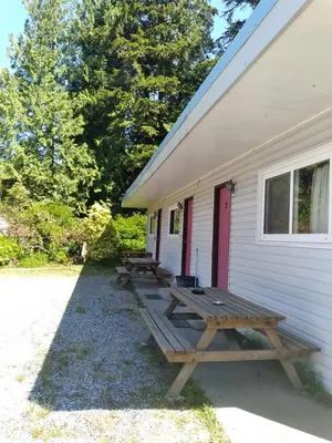 a group of picnic tables on the side of a building at Dolphin Motel in Tofino