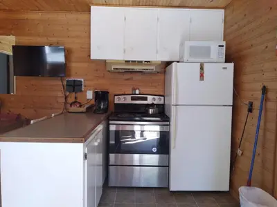 a kitchen with a white refrigerator and a stove at Dolphin Motel in Tofino