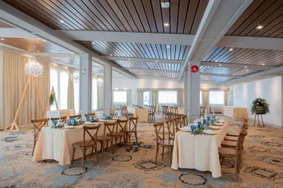a banquet hall with tables and chairs in a room at Prestige Treasure Cove Resort in Prince George