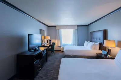 a hotel room with two beds and a flat screen tv at Prestige Treasure Cove Resort in Prince George