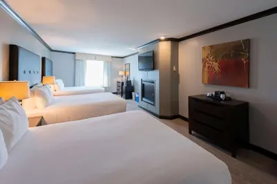 a hotel room with two beds and a television at Prestige Treasure Cove Resort in Prince George