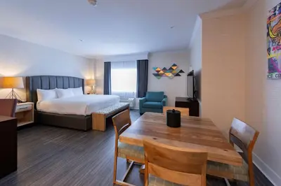 a hotel room with a bed and a table and chairs at Prestige Treasure Cove Resort in Prince George