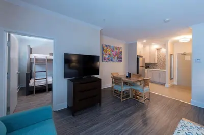 a living room with a television and a dining room at Prestige Treasure Cove Resort in Prince George