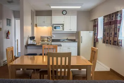 a kitchen and dining room with a table and chairs at Port Augusta Inn in Comox