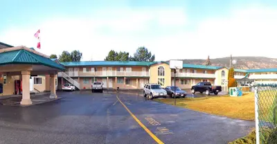 a building with cars parked in a parking lot at Travelodge by Wyndham Merritt in Merritt