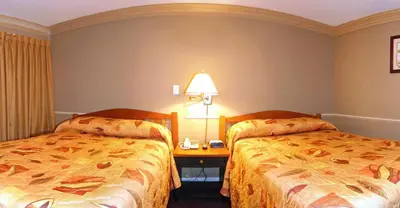 a hotel room with two beds and a table with a lamp at Travelodge by Wyndham Merritt in Merritt