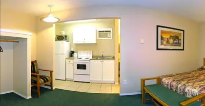 a room with a kitchen and a bedroom with a bed at Travelodge by Wyndham Merritt in Merritt