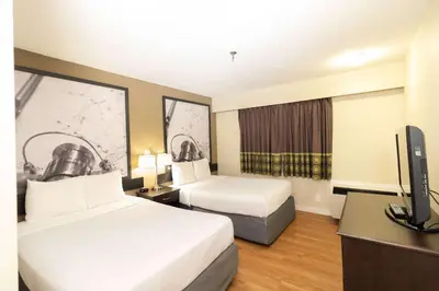 a hotel room with two beds and a flat screen tv at Super 8 by Wyndham Prince George in Prince George