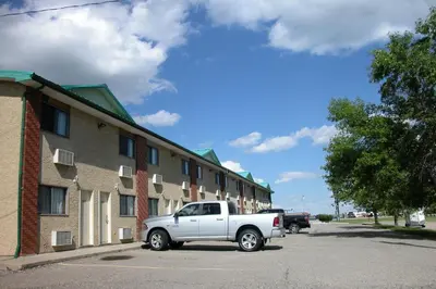 a white truck parked in front of a building at Best Seven Inn in Claresholm