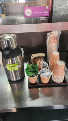 a table with a coffee pot and bowls of food at Best Seven Inn in Claresholm