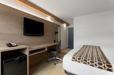 a hotel room with a bed and a desk with a tv at Travelodge by Wyndham Blairmore in Blairmore