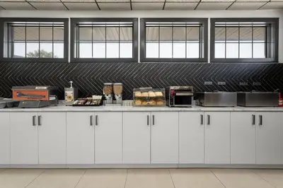 a kitchen with white cabinets and a counter at Travelodge by Wyndham Blairmore in Blairmore