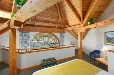 a bedroom with wooden ceilings and a large window at Canadian Princess Lodge & Marina in Ucluelet