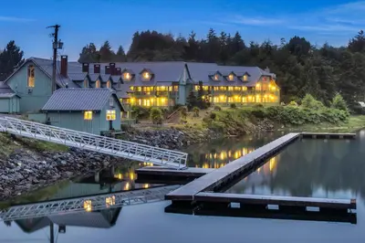a house on the water with a bridge at Canadian Princess Lodge & Marina in Ucluelet