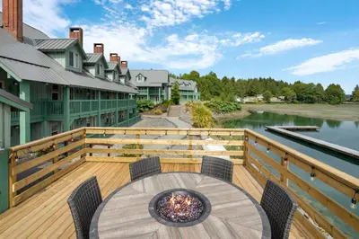 a wooden deck with a table and chairs on the water at Canadian Princess Lodge & Marina in Ucluelet