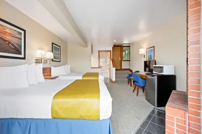 a hotel room with a large bed and a desk at Canadian Princess Lodge & Marina in Ucluelet
