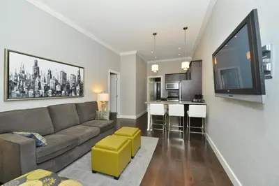 a living room with a couch and a kitchen at Prestige Vernon Hotel in Vernon