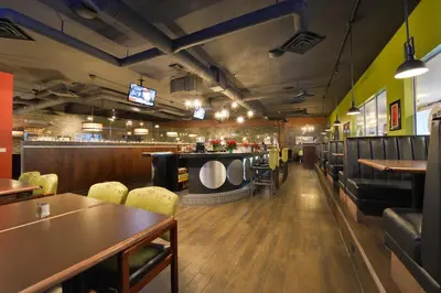 a restaurant with tables and chairs and a bar at Prestige Vernon Hotel in Vernon