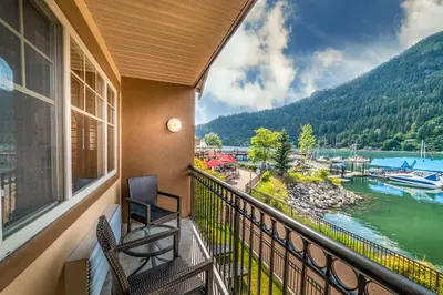 a balcony with two chairs and a view of a river at Prestige Lakeside Resort, WorldHotels Elite in Nelson