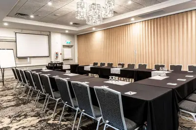a conference room with tables and chairs and a screen at Prestige Lakeside Resort, WorldHotels Elite in Nelson