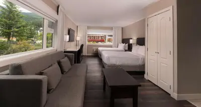 a hotel room with a bed and a couch and a bed and window at Prestige Lakeside Resort, WorldHotels Elite in Nelson