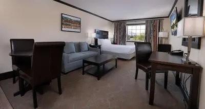 a hotel room with a couch and a bed at Prestige Rocky Mountain Resort Cranbrook, WorldHotels Crafted in Cranbrook