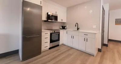 a kitchen with white cabinets and a stainless steel refrigerator at Prestige Rocky Mountain Resort Cranbrook, WorldHotels Crafted in Cranbrook