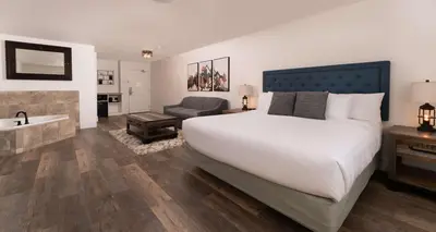 a bedroom with a large bed and a bathtub and a sink at Prestige Rocky Mountain Resort Cranbrook, WorldHotels Crafted in Cranbrook