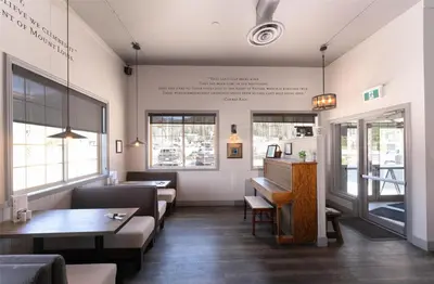 a waiting room with a piano in a restaurant at Prestige Radium Hot Springs Resort, WorldHotels Crafted in Radium Hot Springs