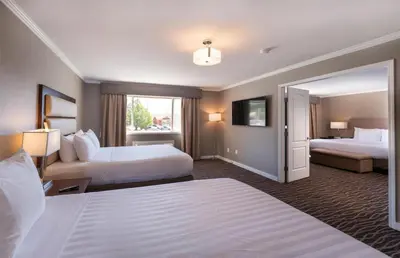 a hotel room with two beds and a mirror at Prestige Radium Hot Springs Resort, WorldHotels Crafted in Radium Hot Springs