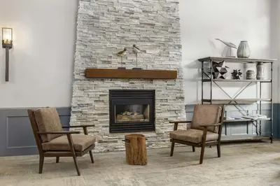 a living room with two chairs and a fireplace at Prestige Radium Hot Springs Resort, WorldHotels Crafted in Radium Hot Springs