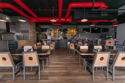 a restaurant with wooden tables and chairs and a bar at Prestige Harbourfront Resort, WorldHotels Luxury in Salmon Arm